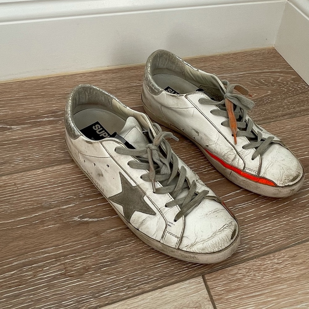 Golden goose superstar sneakers with orange detail and soles